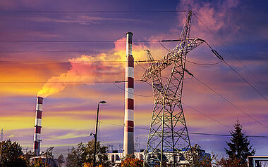 Industriekaminanlage mit Rauchwolken bei Sonnenuntergang.