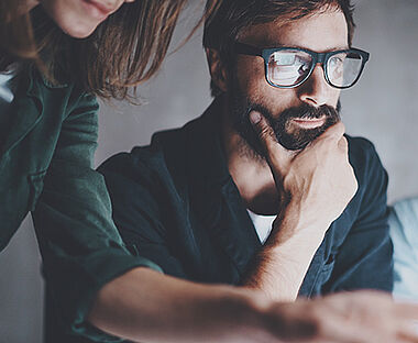 Zwei Personen diskutieren konzentriert über Dokumente am Tisch.