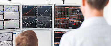 Börsendaten werden auf mehreren Monitoren in einem Kontrollraum angezeigt.