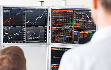 Börsendaten werden auf mehreren Monitoren in einem Kontrollraum angezeigt.