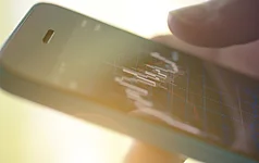 Nahaufnahme von Händen, die ein Smartphone halten.