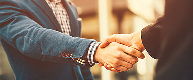 Ein Handschlag zwischen Geschäftspartnern im Büro.