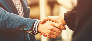 Ein Handschlag zwischen Geschäftspartnern im Büro.